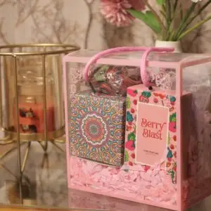 pink hamper box with items as a fragrant candle tin box with a wooden plate for potpourri, women's berry perfume, a wardrobe fragrant kit